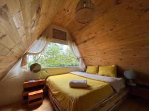 大叻Nấp ở TEEPEE homestay的木制客房的一张床位,设有窗户