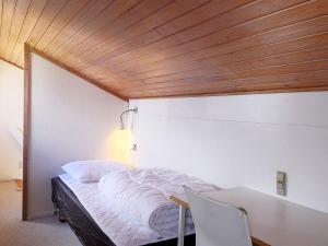 博托比Holiday home Væggerløse CCXIII的一间卧室配有一张桌子和木制天花板的床。
