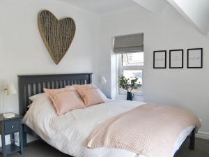 AddinghamLittle Plumtree的卧室配有一张带粉红色枕头的大床