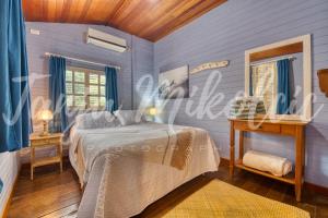 南圣胡安Looking Good Surf House San Juan del Sur的一间拥有蓝色墙壁的卧室,配有一张床和一张桌子