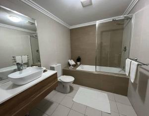 凯阿玛2 bedroom modern coastal retreat的一间带水槽、浴缸和卫生间的浴室