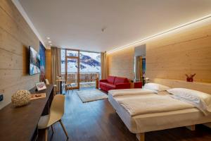 利维尼奥Alpen Resort Bivio的一间卧室配有两张床和红色椅子