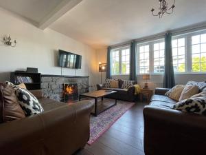 斯佩河畔格兰敦Seafield Lodge的客厅设有两张沙发和一个壁炉