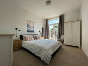 斯佩河畔格兰敦Seafield Lodge的一间卧室设有一张床和一个大窗户