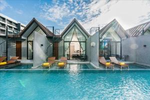 纳仲天Ana Anan Resort & Villas Pattaya的大楼前带游泳池的房子