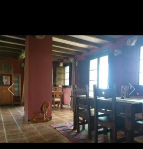 La Rectoral de Valdedios.Casa rural con chimenea的一间带桌子和椅子的用餐室