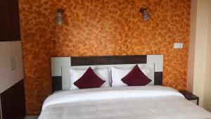 博卡拉Dulcify cottage sarangkot的卧室配有带红色枕头的白色床