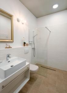 帕波Ditlin Apartmanok的一间带水槽、卫生间和淋浴的浴室