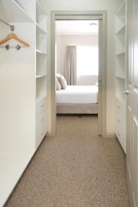 格里菲斯Centrepoint Apartments Griffith的一间卧室配有一张床和一个衣柜