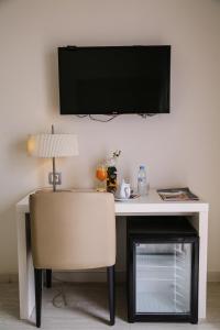 得土安Al Mandari Hôtel Tétouan的一张桌子、椅子和墙上的电视