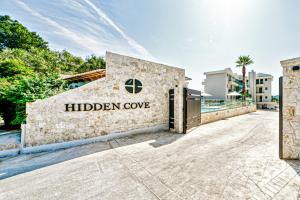 康托卡利Hidden Cove Corfu的上面有隐秘的海湾标志的建筑