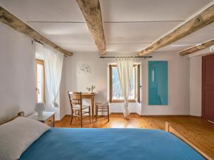 BorgnoneOsteria Grütli con alloggio的一间卧室配有一张蓝色的床和一张桌子