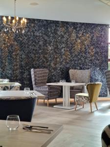 波兹南Grand Royal Hotel的一间带桌椅和图案墙壁的用餐室