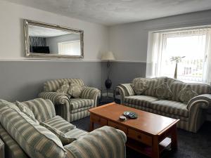 LeslieClarkes 1st floor Apartment Leslie- Golf Paradies的带沙发、桌子和镜子的客厅