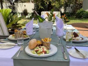 利隆圭Burley House by Ulendo的餐桌,带食物盘和一瓶葡萄酒