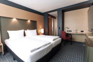 埃森Ramada by Wyndham Essen的酒店客房设有一张大床和一张书桌。