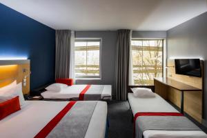 巴黎快捷假日巴黎加纳尔德拉维莱特酒店的一间酒店客房,设有两张床和电视