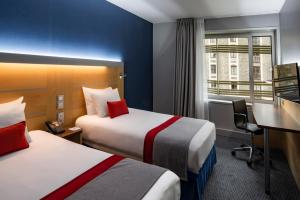 巴黎快捷假日巴黎加纳尔德拉维莱特酒店的酒店客房配有两张床和一张书桌