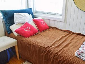 赫讷福斯Holiday home Hønefoss的一张带红色枕头的床和窗户