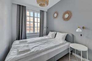 格但斯克Comfort Apartments Długi Targ的白色的卧室设有床和窗户