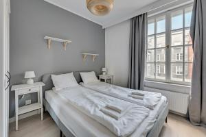 格但斯克Comfort Apartments Długi Targ的白色的卧室设有一张大床和一个窗户