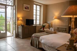 埃雷皮扬埃雷皮昂修道院酒店的一间卧室设有一张床、一台电视和一个阳台。