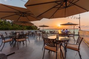 巴统Capo Verde Hotel Batumi的一个带桌椅和遮阳伞的庭院。