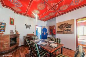 舍夫沙万Casa Plasa Grande CHAOUEN的一间设有桌子和红色天花板的用餐室