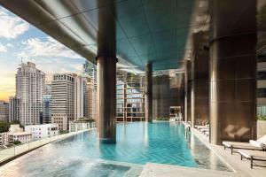 曼谷曼谷新通凯宾斯基酒店的一座城市建筑屋顶上的游泳池