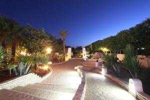 兰佩杜萨Agriturismo Resort Costa House的一条棕榈树和灯光的夜间步道