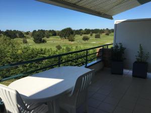 波尔尼克La Terrasse du golf的享有田野美景的阳台上配有桌椅