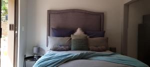 比勒陀利亚The Moore Guesthouse的一间卧室配有一张带蓝色床单和枕头的床。