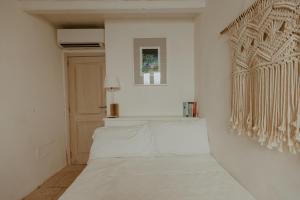 滨海波利尼亚诺Elena's house 30的白色的客房设有床和窗户。