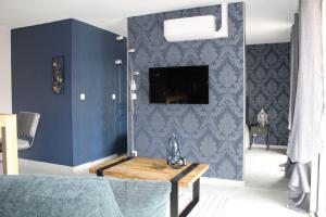 丰特奈勒孔特Althéa, gîte de charme et bien être的客厅设有蓝色的墙壁和桌子