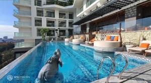 绥和市Kings House Apec Condotel Phú Yên的海豚在一座大楼的游泳池里