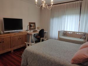 莱萨马Karaltzos LB00530的一间卧室配有一张床和一张书桌及电视