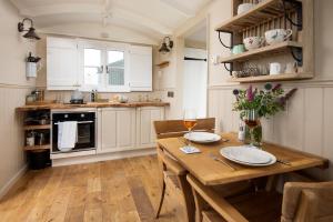 GreenheadWagtail的厨房配有白色橱柜和木桌
