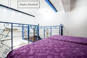 巴黎贝莱尔大酒店的一间卧室配有紫色床和紫色棉被