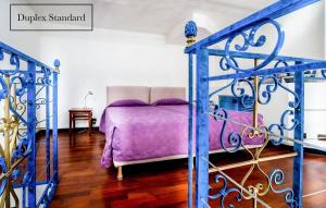 巴黎贝莱尔大酒店的一间卧室配有一张带紫色毯子的床