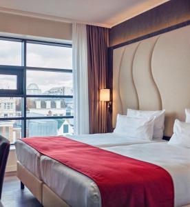 海牙Best Western Plus Plaza Den Haag City Center的一间酒店客房,设有一张大床和一个大窗户