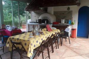 JurançonVilla de 4 chambres avec piscine privee terrasse amenagee et wifi a Jurancon的一间带桌椅和烤箱的用餐室