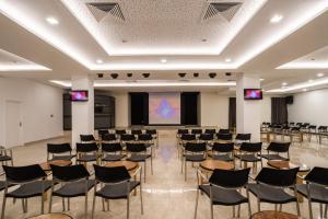 哈马马特达哈亚姆酒店的大房间设有椅子和投影屏幕