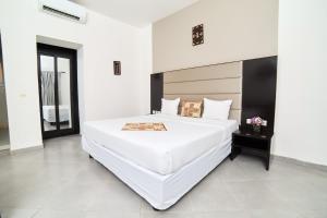 巴马科Dunia Hotel Bamako的一间白色的大卧室,配有一张白色的大床