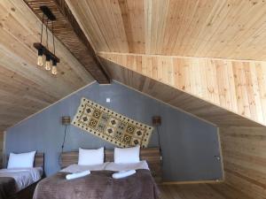 卡兹贝吉Hotel Nestt的配有木天花板的客房内的两张床