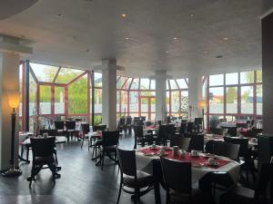 特劳恩罗伊特莫扎特酒店的用餐室设有桌椅和窗户。