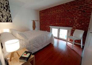 蒙得维的亚Zabalita, hermoso y cálido loft en la Ciudad Vieja的一间卧室设有一张床和砖墙