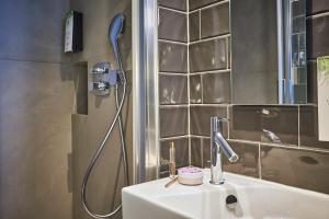 巴黎Hotel Campanile Paris-Bercy Village的一间带水槽和淋浴的浴室