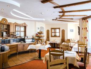 伊施格尔Hotel Garni Daniel的厨房以及带桌椅的用餐室。