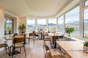 UnapoolNewton Lodge的餐厅设有桌椅和大窗户。