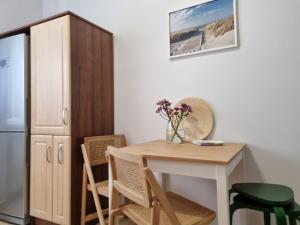 格丁尼亚Apartament na Żeromskiego的厨房配有桌椅和冰箱。